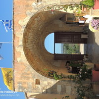 Agios Giorgos entrance with cat and flags.